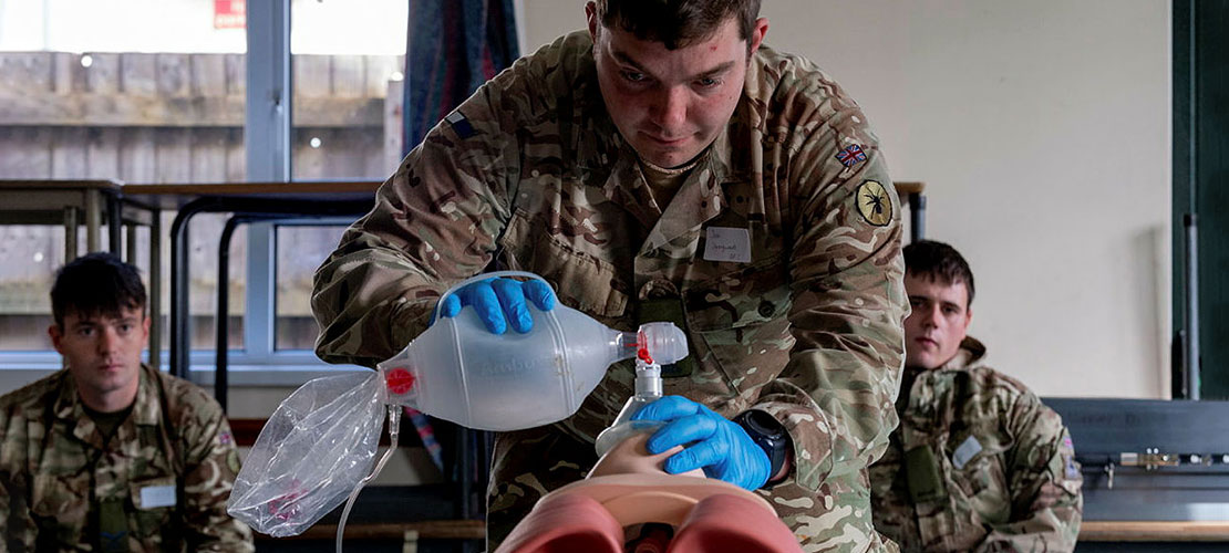 Medical Training - showing three soldiers with one administering artificial respiration on a medical dummy