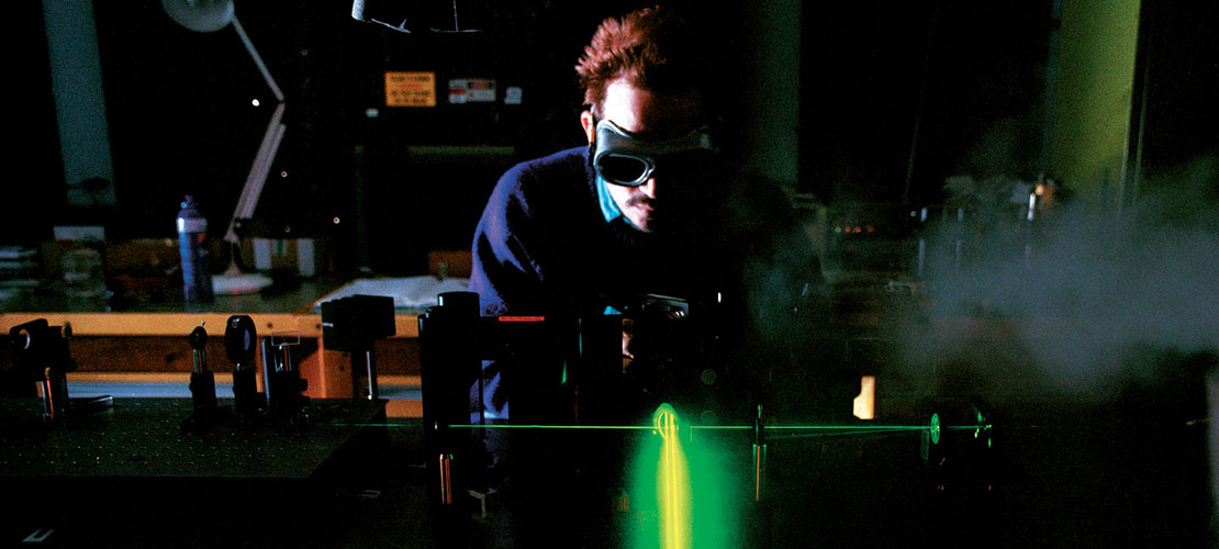 QinetiQ advice and engagement supporting the National Quantum Technologies Programme showing laser in use by operative wearing goggles in lab