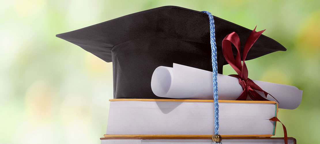 Graduation hat with scroll and books
