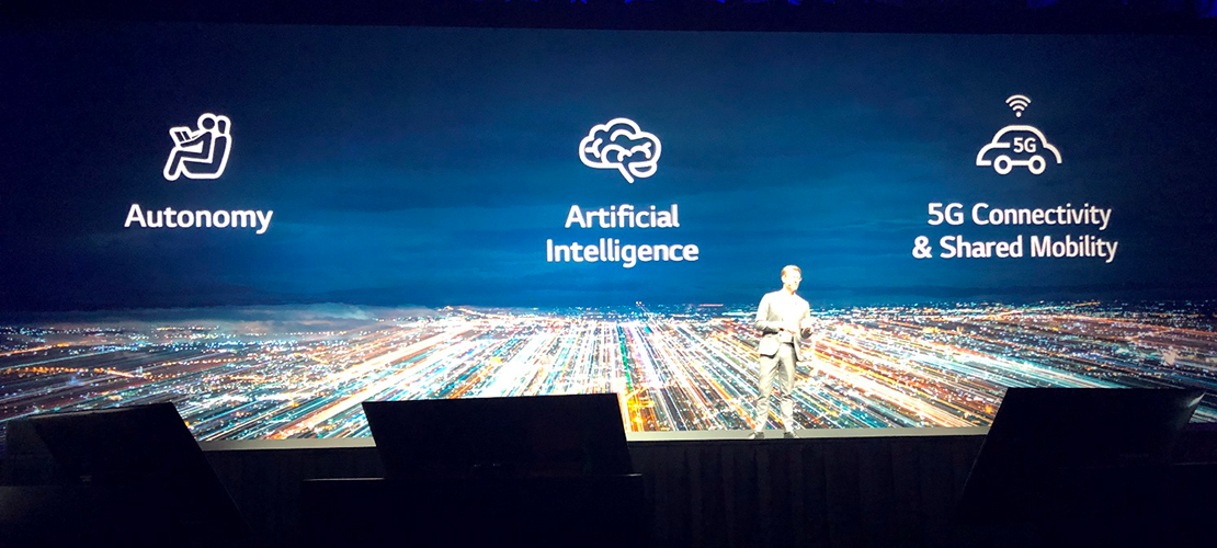 CES 2019 image showing speaker on stage in front of Autonomy AI and 5G signs