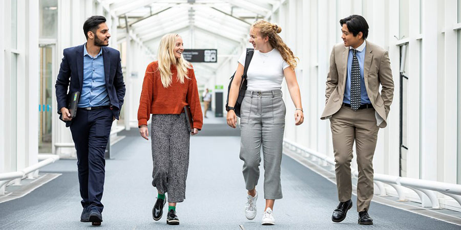 4 employees walking down concourse